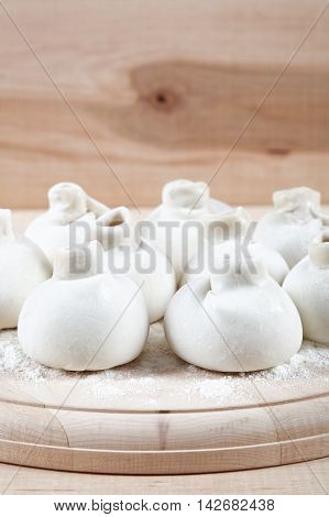 Manti dumplings on the a wooden board.
