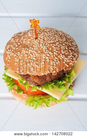 Hamburger with salad tomato meat on white backdrop. Popular snack.