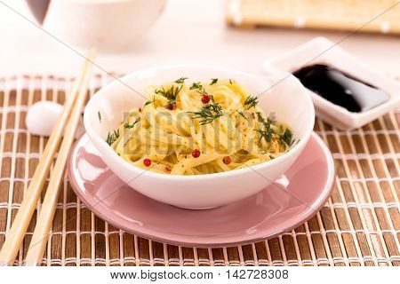 Bowl of noodles with spice on table