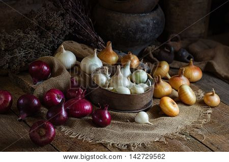 Yellow red and white onions on a wooden surface. Rusic style