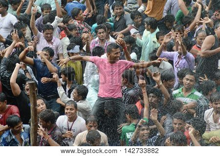 AMRAVATI, MAHARASHTRA, INDIA - AUGUST 29 : Crowd of young People enjoying "Govinda" at Dahi Handi festival to celebrate God Krishna's Birth in Amravati, Maharashtra, India. 29 August 2013