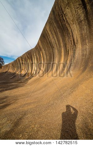 Fantastic Wave Rock in the Wave Rock Wildlife Park near Hyden in Western Australia.Wide angle shot with man's shadow.