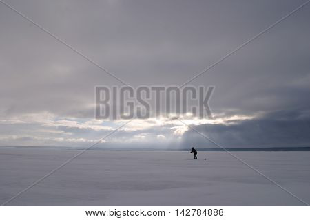 Fisherman On The River Covered With Ice