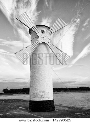 White Windmill By Sea On Rocky Coast. Seascape And Landscape
