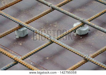 SELANGOR, MALAYSIA -SEPTEMBER 19, 2015: Hot rolled deformed steel bars or steel reinforcement bar and the concrete spacer. The spacer used to created gap between reinforcement bar and the form work.