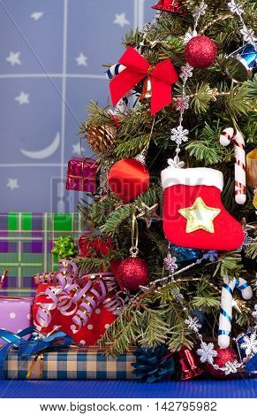Christmas toy balls with garland over presents and christmas spruce background