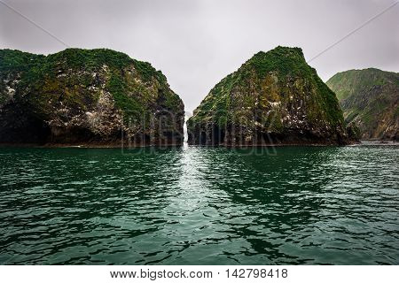 Passage between rocky cliffs that form the coastline of the Avacha Bay, Kamchatka, Russia
