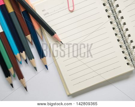 Top view notebook with pencil on white background