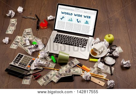 Laptop computer on wooden desk with office suplies