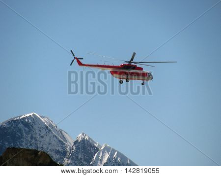 Helicopter flying in the background of snowy mountains