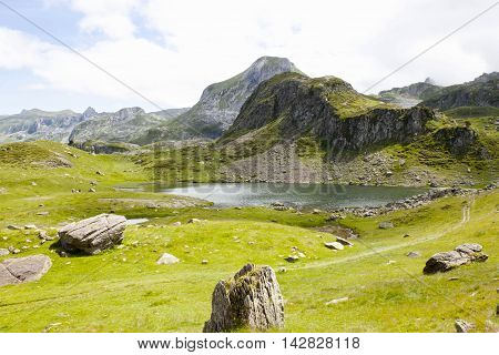 Ayous Lake Sorrounded Of Stones And Green Grass In Pyrenees, France