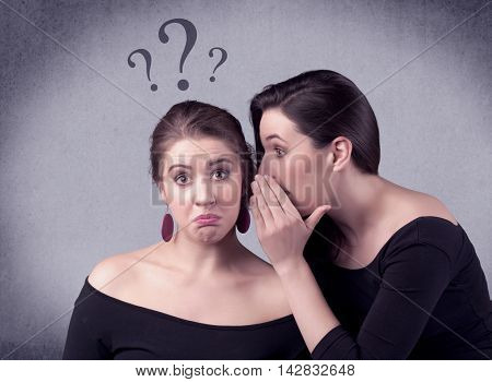 A teenager girl looking confused with drawn question marks above the head, while a girlfriend whispers something in her ear concept.