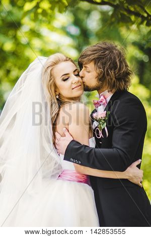 Elegant bride and groom posing together outdoors on a wedding day