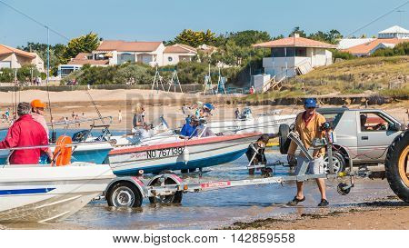 Men Getting Boats Out Of Water With Tractors On The Beach