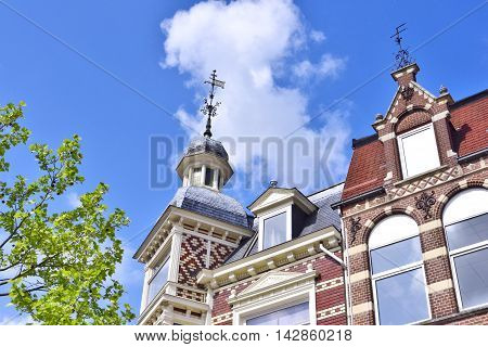 Lovely, historic house facade with turret and blue sky.
