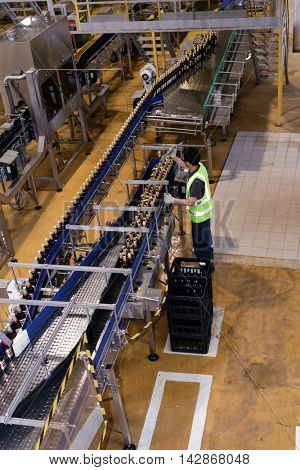 ST. PETERSBURG, RUSSIA - AUGUST 11, 2016: Worker at beer conveyor in the Heineken brewery. It was the first Heineken brewery in Russia, and now it can produce over 5 millions HL of beer per year