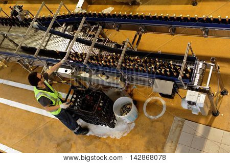ST. PETERSBURG, RUSSIA - AUGUST 11, 2016: Worker at beer conveyor in the Heineken brewery. It was the first Heineken brewery in Russia, and now it can produce over 5 millions HL of beer per year