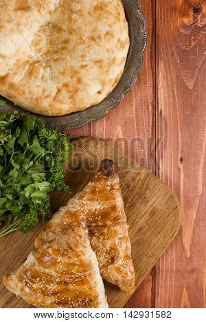 Traditional Uzbek bread and samosas on wooden background