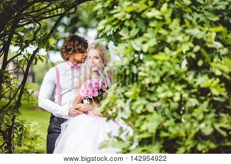 Elegant bride and groom posing together outdoors on a wedding day