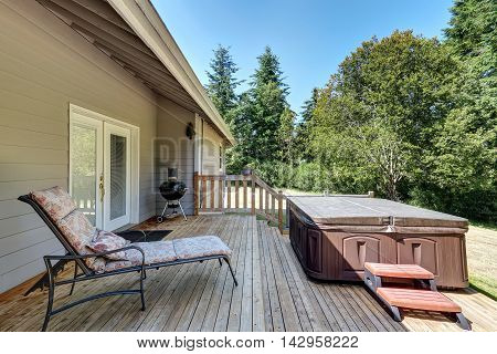Backyard House Exterior With Patio Area And Hot Tub On The Walkout Deck.