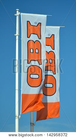CIRCA AUGUST 2016 - GDANSK: sign of OBI on waving flags against blue sky. OBI is the largest do it yourself retailer in Europe. It was founded in 1970 in Hamburg, Germany.