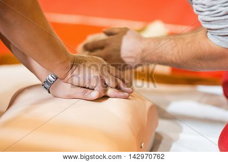 CPR chest compressions - paramedics practicing with CPR dummy