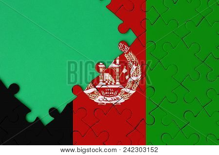 Afghanistan Flag Is Depicted On A Completed Jigsaw Puzzle With Free Green Copy Space On The Left Sid
