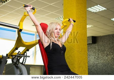 Sport, Fitness, Lifestyle And People Concept - Close Up Of Young Woman Flexing Muscles On Cable Gym 