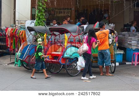 YOGYAKARTA - AUGUST 03: Traditional rikshaw transport on streets of Yogyakarta, Java, Indonesia on August 03, 2010. Bicycle rikshaw remains popular means of transport in many Indonesian cities.