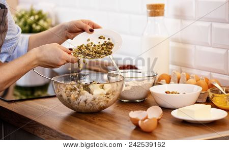 Women's Hands Prepare Dough With Nuts And Seeds For Cookies