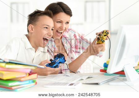 Mother And Son Playing Computer Game With Laptop