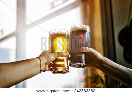 Alcohol. Two Man Cheers And Clinking Glass Of Beer Drinking And Toasting Outdoor After Work. October