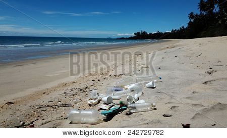 Plastic pollution on beach. Plastic water bottles, syrofoam cups and carrier bags pollute a tropical beach 