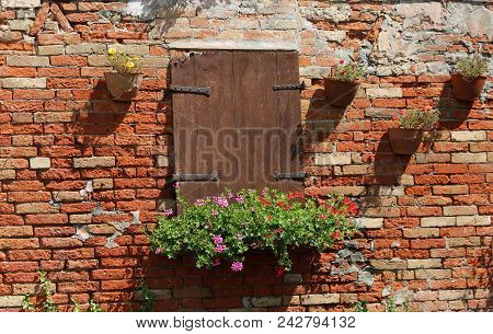 Purple And Red Flower Pot Outside The Balcony Of A Red Brick House