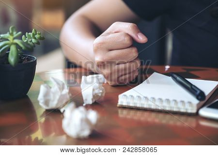 Closeup Image Of A Businesswoman Upset And Screwed Up Papers On Table With Notebook And Mobile Phone