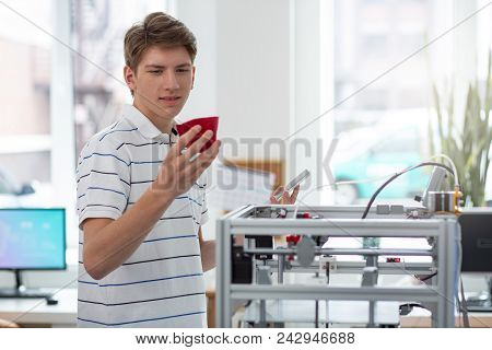 Flawless Model. Pleasant Young Engineer Looking For Flaws In A Bell Pepper Model, Having Printed Wit