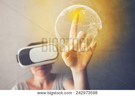 Woman Immersed In Virtual Reality Pointing To Great Britain On World Map, Female Person Using Modern