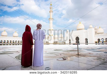 Arab Couple Visiting The Grand Mosque In Abu Dhabi Wearing Traditional Dress Back View