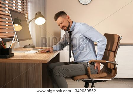 Man Suffering From Hemorrhoid At Workplace In Office