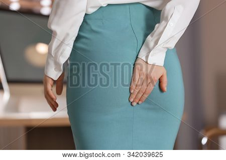 Young Woman Suffering From Hemorrhoid In Office, Closeup