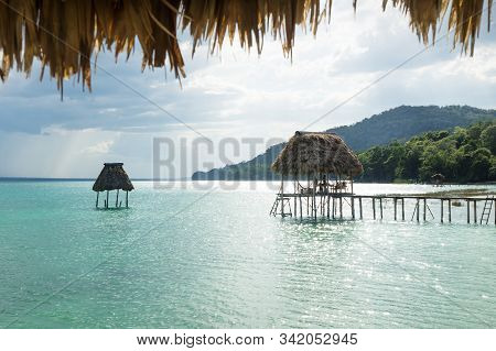 Sunlit Dock At Lake Itza With Green Crocodile Shaped Mountain, El Remate, Peten, Guatemala