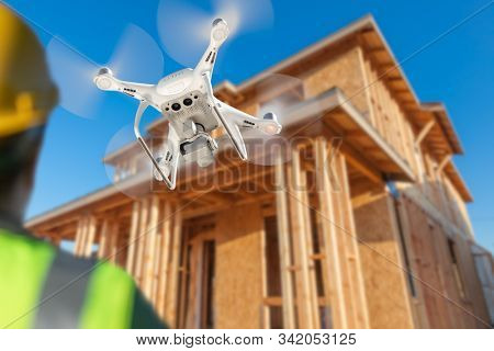 Pilot Flies Drone Quadcopter Inspecting Home Construction Site.