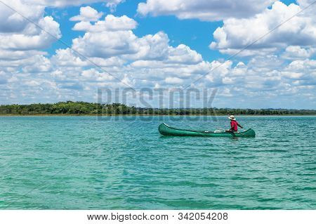 El Remate, Peten, Guatemala - 29 May 2019: Fisherman In Canoe Boat In Turquoise Colored Lake Itza Wi