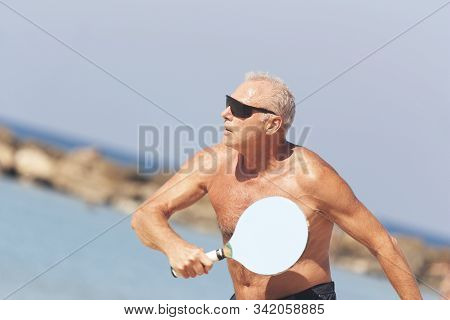 Adult Male Playing Matkot On The Beach