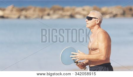 Adult Male Playing Matkot On The Beach