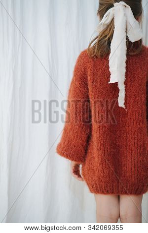 Little Girl In Sweater With Bow-knot From Self Made Tape. From Behind.
