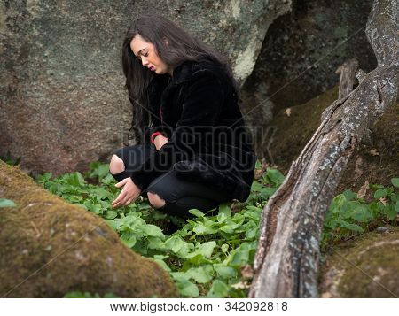 Young Woman Behind The Rocks. Person In Nature.