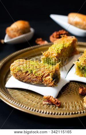 Food Concept Oriental Arab Dessert Baklava Walnuts And Rolled Kanafeh On Black Slate Board With Copy