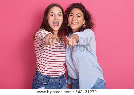 Image Of Smiling Breunette Girls Posing Isolated Over Pink Sudio Background, Looking Amd Pointing At