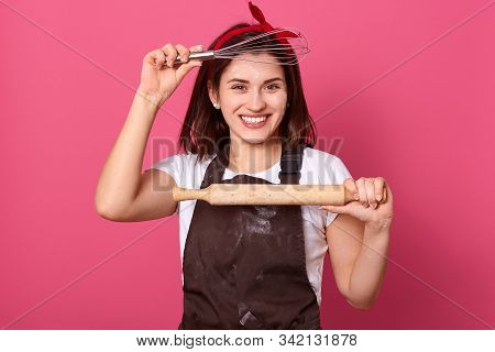 Happy Young Professional Cook Posing Firmly Isolated Over Pink Background, Holding Rolling Pin And W